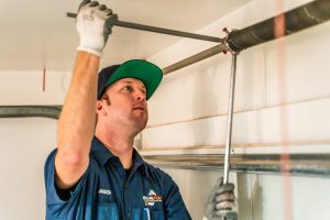 Garage Repair Mechanic Fixing Spring with Wrenches.